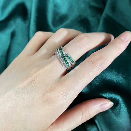An exquisite X-shaped ring, crafted from 925 sterling silver and set with dazzling emerald gemstones. A timeless piece that reflects elegance and sophistication.