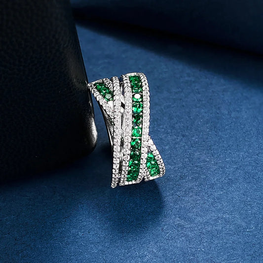 An exquisite X-shaped ring, crafted from 925 sterling silver and set with dazzling emerald gemstones. A timeless piece that reflects elegance and sophistication.